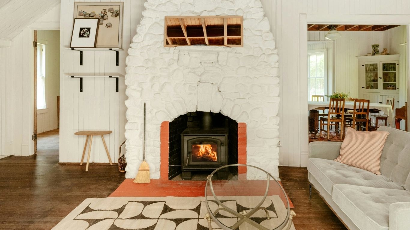 Cozy white stone fireplace highlighting the warm style of direct vent fireplaces.