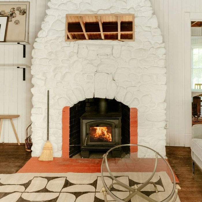 Cozy white stone fireplace highlighting the warm style of direct vent fireplaces.