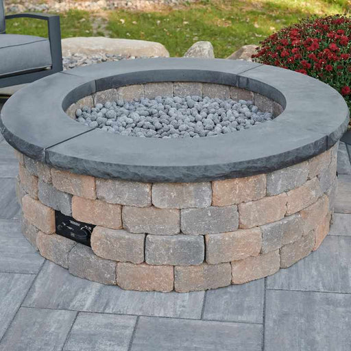Bronson Block Round Gas Fire Pit Kit Placed at Frontyard with Charcoal Grey Tops and Tumbled Lava Rock Scaled