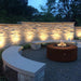 Corten Steel Unity Aged Corten Night Photo with Lava Rock plus Fire Burner On Installed at Campfire Circle V1