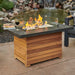 Darien Rectangular Gas Fire Pit Table with Aluminum Top with Clear Tempered Fire Glass Gems On Fire, Gas Tank Door Open near Pond with Wine