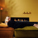 Element4 Summum 190 F with a gorgeous lady relaxing at the Living room with Real Flame Burner with True-to-Nature Wood Logs