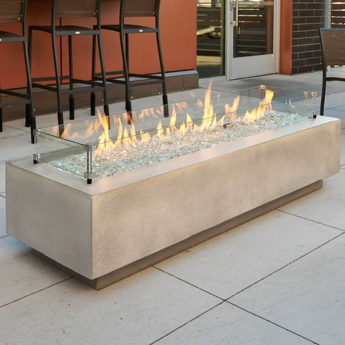 Natural Grey Cove 72 Linear Gas Fire Pit Table at the Front Yard with Clear Tempered Fire Glass Gems plus Fire Burner On and Glass Wind Guard Installed