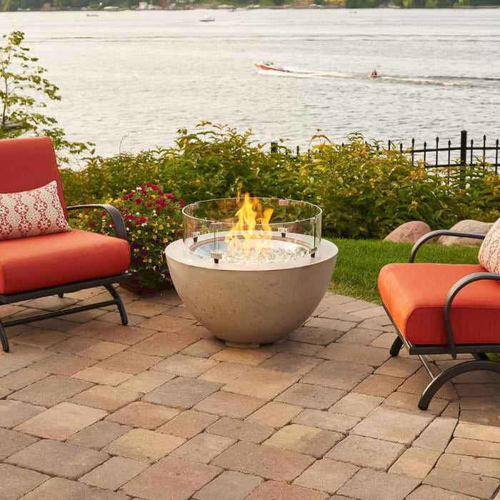 Outdoor Greatroom Natural Grey Cove 29 Round Gas Fire Pit Bowl Placed at Garden Sea Side with Clear Tempered Fire Glass Gems  plus Fire Burner On with Glass Wind Guard Cover