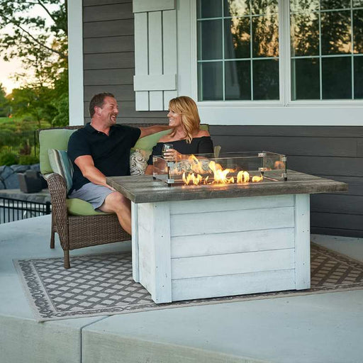 Rectangular Glass Wind Guard Installed on Alcott Rectangular Gas Fire Pit Table plus Fire Burner On with Family