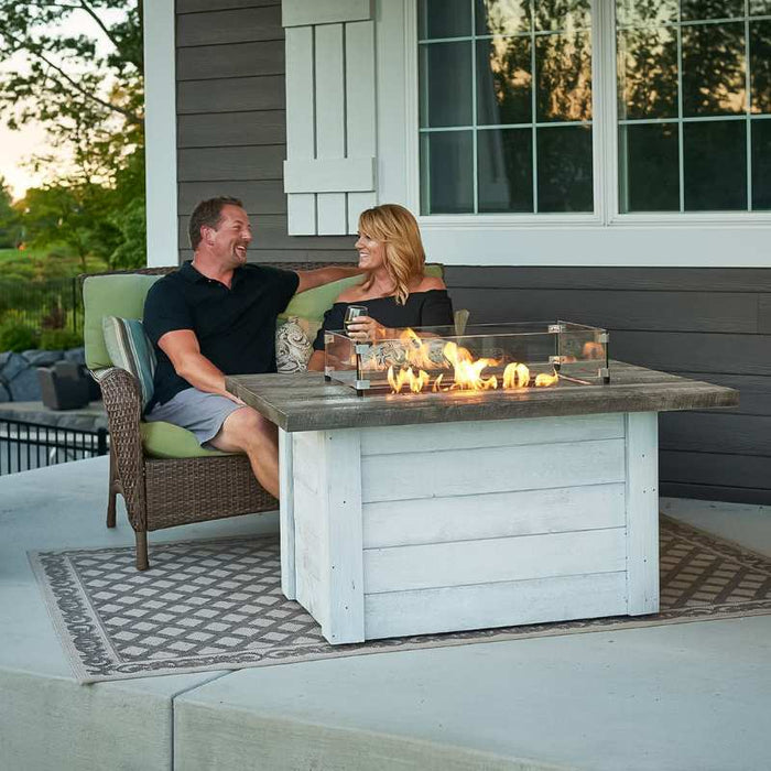 Rectangular Glass Wind Guard Installed on Alcott Rectangular Gas Fire Pit Table plus Fire Burner On with Family