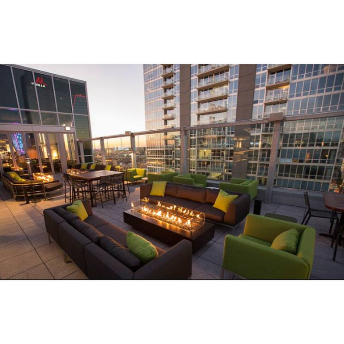 The Distric Fire Pit - GFRC Concrete  72" with Wind Guard and Black Fire Glass Placed in Hotel Rooftop Restaurant Lounge Area V2