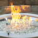 The Outdoor Greatroom 20 Round Glass Wind Guard installed on Cove Round Gas Fire Pit Bowl plus Fire Burner On with Clear Tempered Fire Glass Gems Scaled