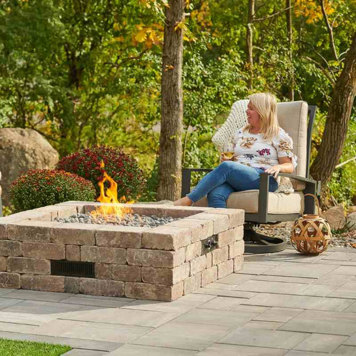 The Outdoor Greatroom Bronson Block Square Gas Fire Pit Kit Installed at Front Yard with Tumbled Lava Rock Fire Burner On