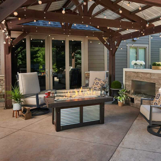 The Outdoor Greatroom Denali Brew Linear Gas Fire Pit Table At the Terrace with Clear Tempered Fire Glass Gems plus Fire Burner On and Glass Wind Guard V1