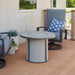 The Outdoor Greatroom Grey Stonefire Round Gas Fire Pit Table Installed at Deck with Composite Burner Cover