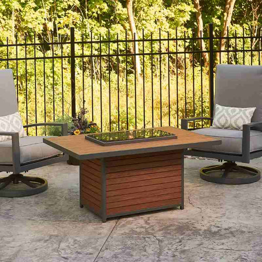 The Outdoor Greatroom Kenwood Rectangular Gas Fire Pit Table place on Guess Waiting Area with Grey Glass Burner Cover installed