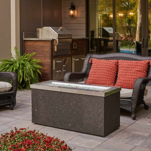 The Outdoor Greatroom Stainless Steel Key Largo Linear Gas Fire Pit Table Placed at the Deck with Clear Tempered Fire Glass Gems