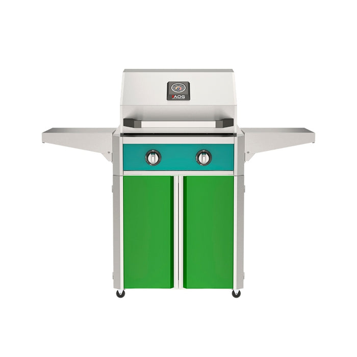 American Outdoor Grill 24" T-Series Portable Gas Grill with teal accent panel and green accent panel cart base, large analog thermometer and push-button electronic ignition with backlit comfort-touch control knobs.
