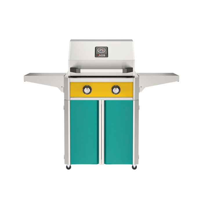 American Outdoor Grill 24" T-Series Portable Gas Grill with yellow accent panel and teal accent panel cart base, large analog thermometer and push-button electronic ignition with backlit comfort-touch control knobs.
