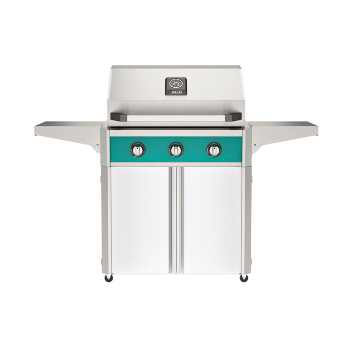 American Outdoor Grill 30" T-Series Portable Gas Grill with teal accent panel and white accent panel cart base, large analog thermometer and push-button electronic ignition with backlit comfort-touch control knobs.
