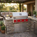 American Outdoor Grill 36" T-Series Built-In Gas Grill (AOG36TN) installed in a stacked stone outdoor kitchen island with a dark granite countertop on a luxury patio setting.