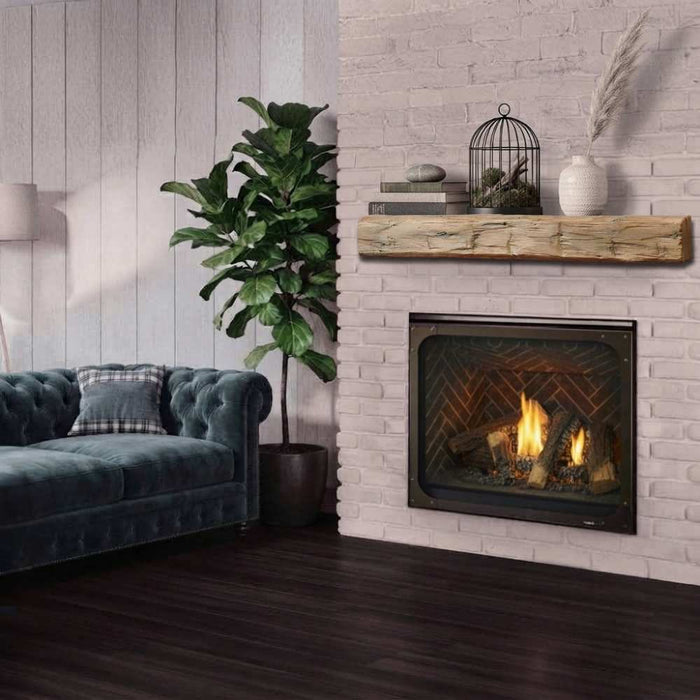 Fireside finishings weathered barnwood traditiopnal non-combustible mantel shelf installed above a gas fireplace in a rustic living room.