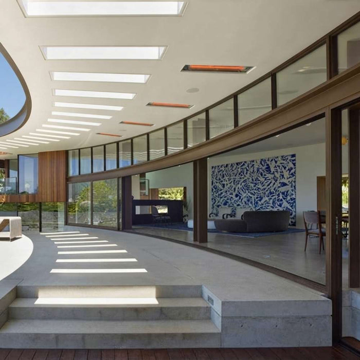 Infratech WD-series electric patio heater   recessed into the curved architectural eave of a modern luxury breezeway.