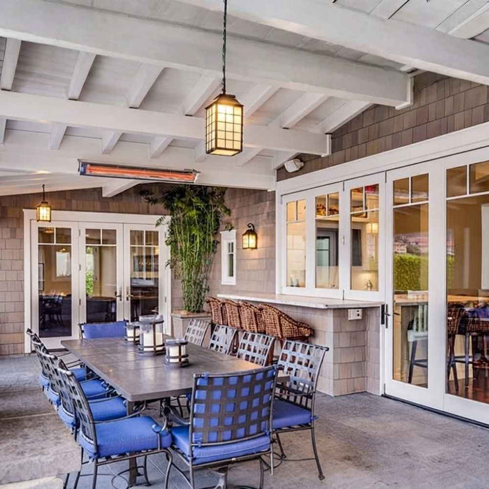Infratech WD-series electric patio heater installed in a covered patio with an open-rafter ceiling and dining setup.