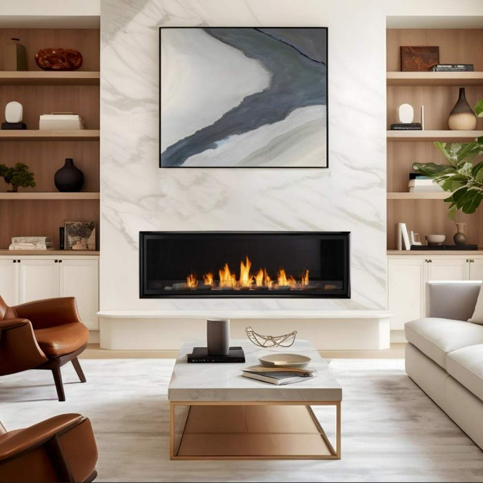 Monessen Artisan vent free linear gas fireplace featuring a black trim frame, stone kit media, and natural orange flames in a luxury living space.