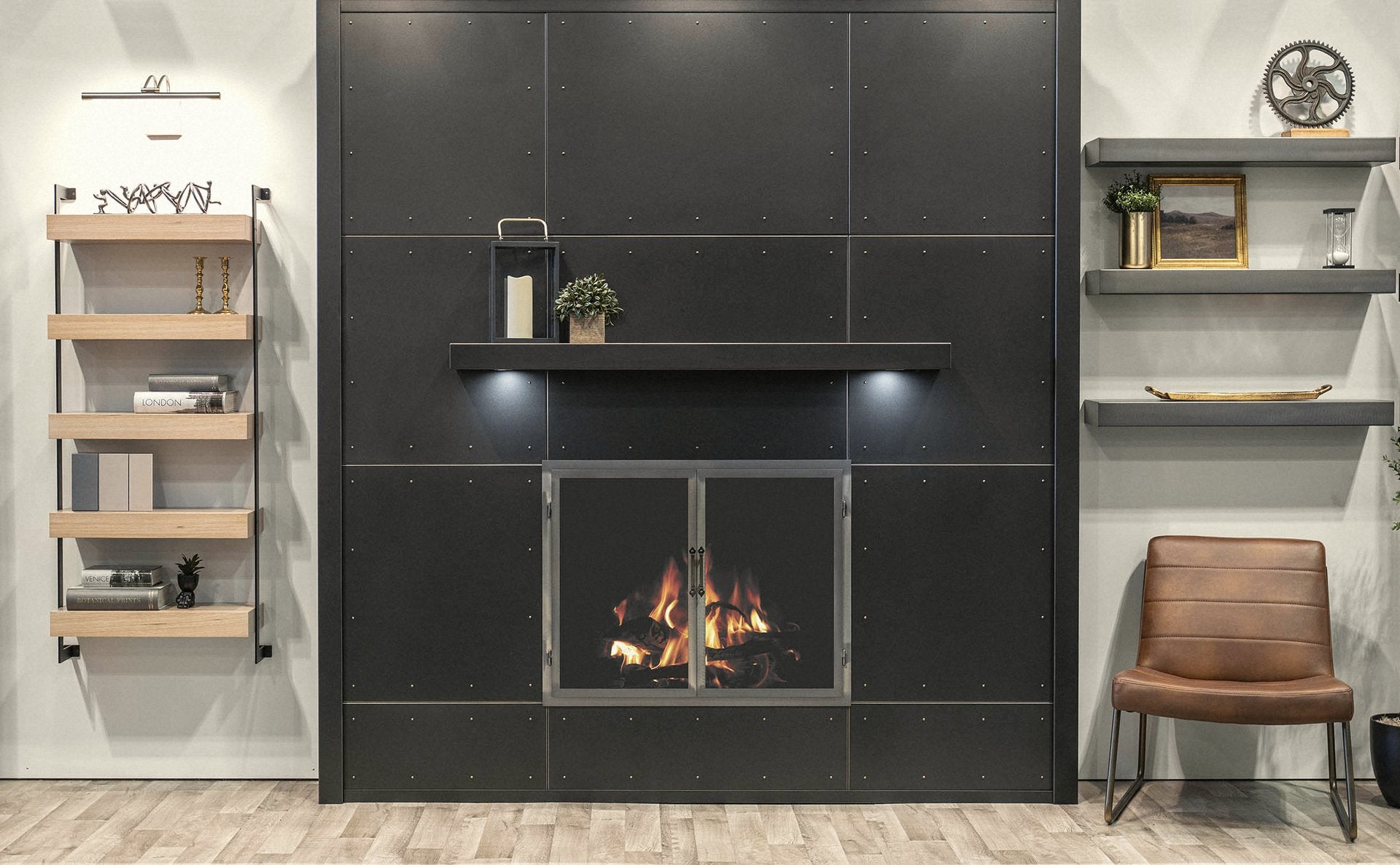Modern fireplace with custom black metal door set into a riveted dark-panel wall, flanked by floating wood shelves and a leather chair.